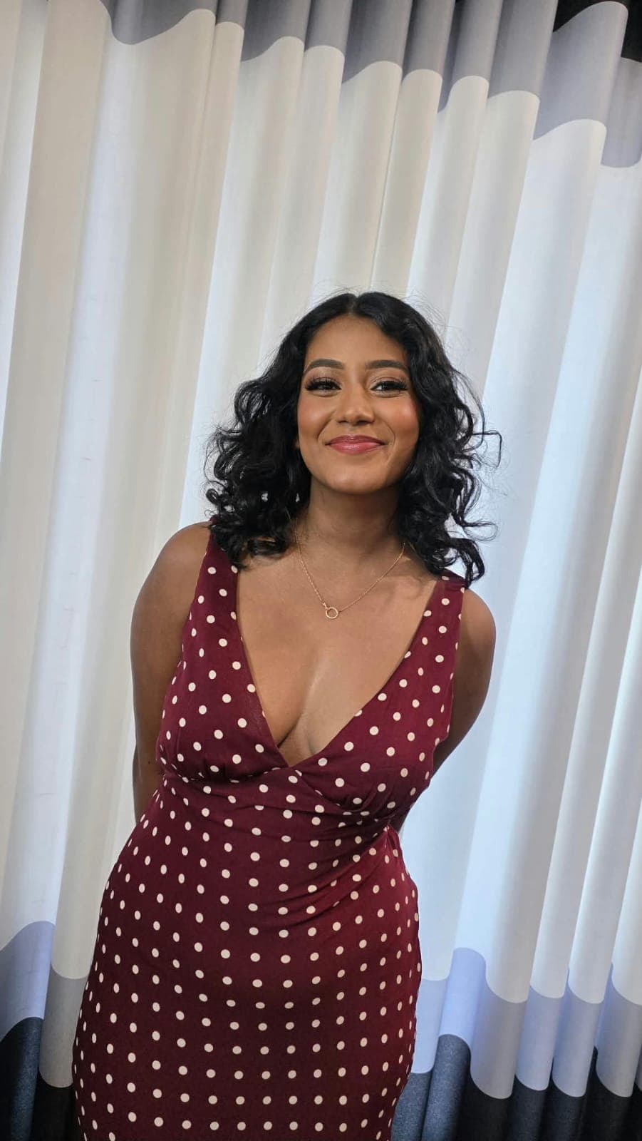 Special-occasion makeup and curled hair with a maroon polka-dot dress