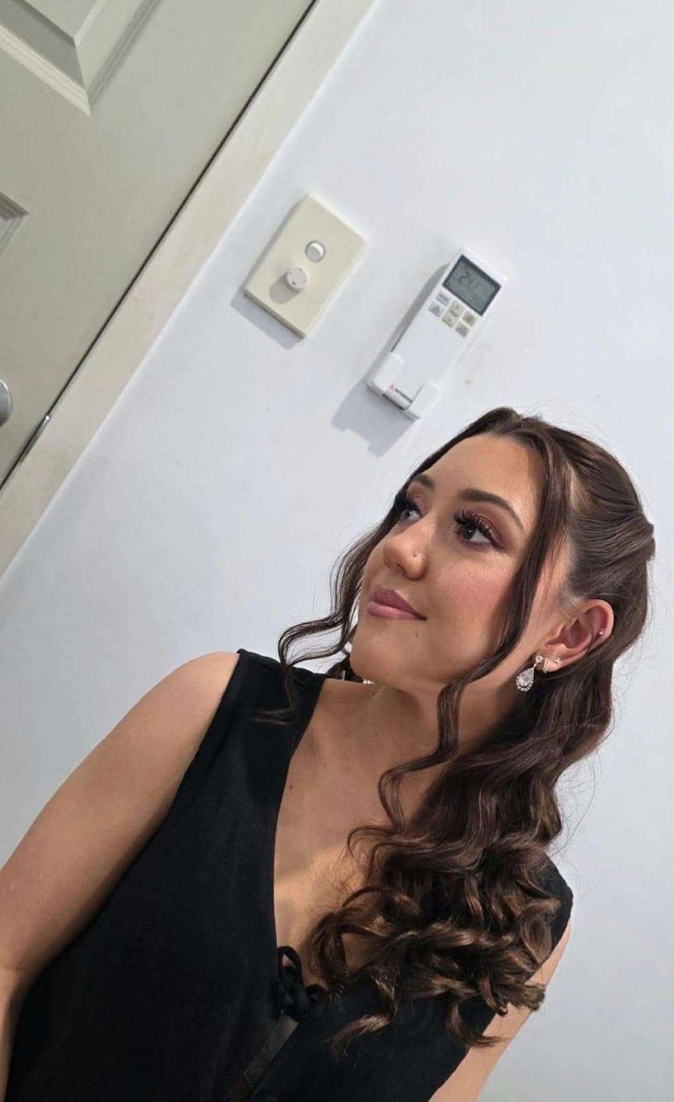 Soft glam formal makeup with mauve eyeshadow and loose curls, in a black dress