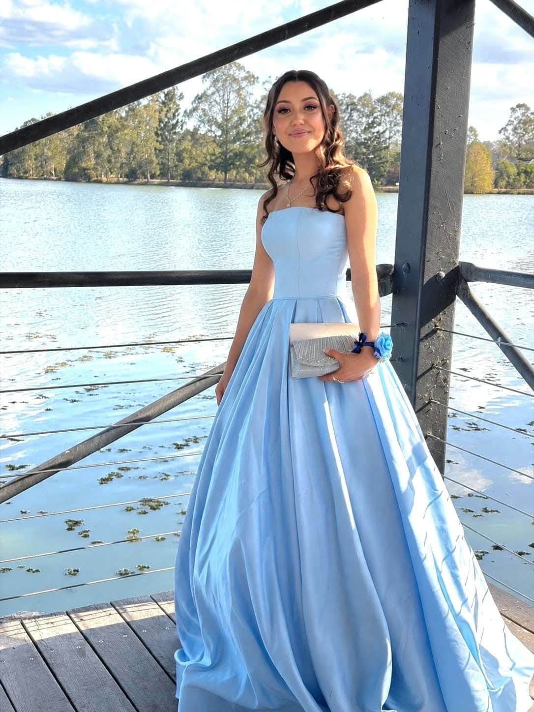School formal makeup and soft curls with a pale blue strapless gown, photographed by the water